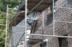 worker removing mortar from brick wall joints Kitchener ON